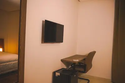a room with a desk and a television on the wall at EL MOUSSAFIR HOTEL in Marrakech