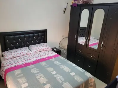 a bedroom with a bed and a dresser and a mirror at 90 qm Wohnung mit 2 Schlafzimmern in Marrakech