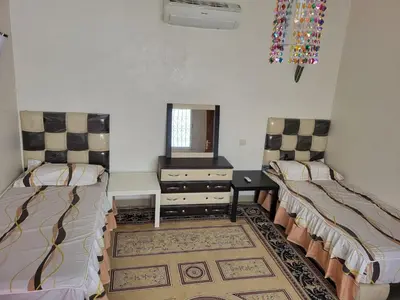 a room with two beds and a dresser and a mirror at 90 qm Wohnung mit 2 Schlafzimmern in Marrakech