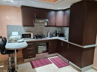 a kitchen with wooden cabinets and a counter top at Luxury apartment in the heart of Gueliz , Wifi, Pool in Marrakech