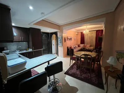 a kitchen and a living room with a table and chairs at Luxury apartment in the heart of Gueliz , Wifi, Pool in Marrakech