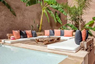 a poolside seating area next to a swimming pool at dar al walidine in Marrakech