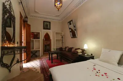 a bedroom with a bed and a living room at Riad Maissoun in Marrakech