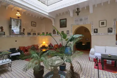 a living room filled with furniture and plants at Riad Maissoun in Marrakech