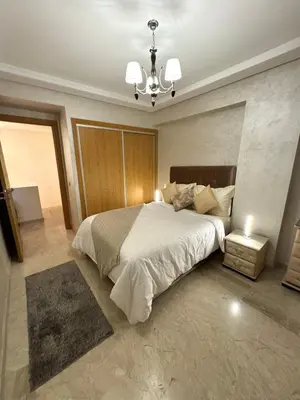 a bedroom with a large bed and a chandelier at Duplex Sabah Opera - Quartier Hivernage in Marrakech