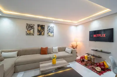 a living room with a couch and a tv at LUXURY APARTMENT IN THE HEART OF MARRAKECH GUELIZ in Marrakech