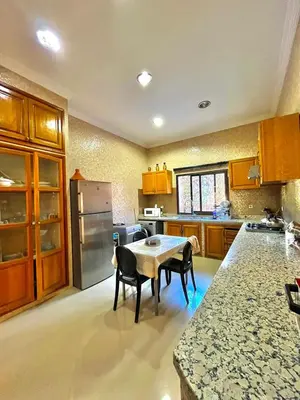 a kitchen with a table and some chairs in it at villa ibtissam in Marrakech
