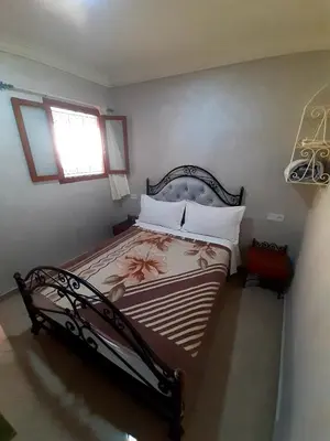 a bedroom with a bed with a flower on it at Hotel salem leksor in Marrakech