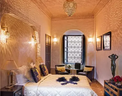 a bedroom with a large bed and a sitting room at Riad Star by Marrakech Riad in Marrakech