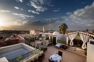 a rooftop patio with a pool on a building at Riad Star by Marrakech Riad in Marrakech