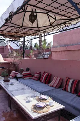a couch sitting under an umbrella on a patio at Riad Dar Habiba by Garden Wonders in Marrakech