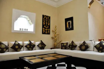 a living room with a white couch and a table at Riad l'Escale de Marrakech in Marrakech