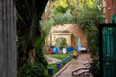 a garden with a gate and trees and plants at Riad AMBER ZAHRA in Marrakech