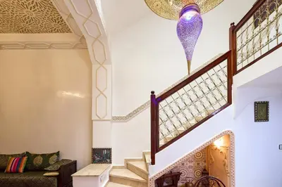 a staircase in a house with a purple chandelier at Riad AMBER ZAHRA in Marrakech