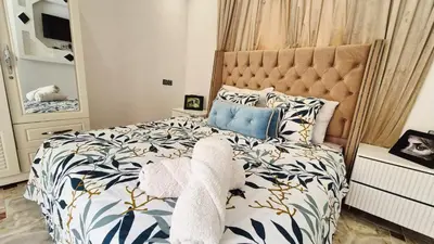 a bedroom with a bed with a blue and white comforter at Le clos des oliviers de Marrakech in Marrakech