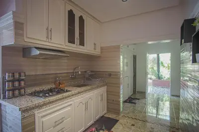a kitchen with white cabinets and a sink at Le clos des oliviers de Marrakech in Marrakech