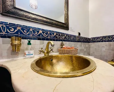 a gold sink in a bathroom with a mirror at Duplex Atlas Golf Resort Pοοl νieω Seriniτყ & Cαlm in Marrakech