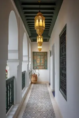 a hallway with a chandelier and a rug at Riad les remparts de la kasbah in Marrakech