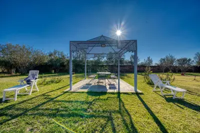a gazebo with a picnic table in a field at Villa Maloulou in Marrakech
