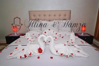 two swans dressed in white are on a bed at Illina & Hamza Apartment in Marrakech