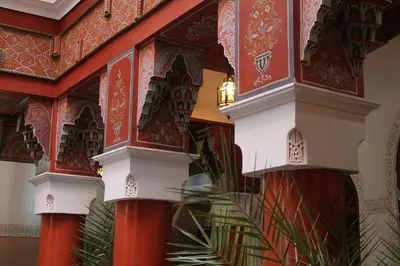 a building with red and white pillars in a room at Riad Souad Marrakech in Marrakech