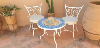 a table and two chairs with a plate on it at Riad Souad Marrakech in Marrakech