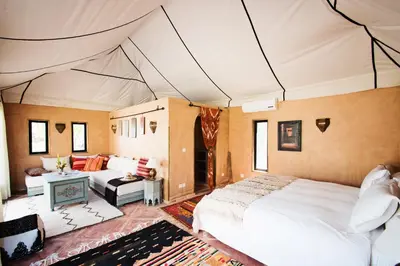 a bedroom with a bed and a living room at Villa Dinari in Douar Caïd Layadi