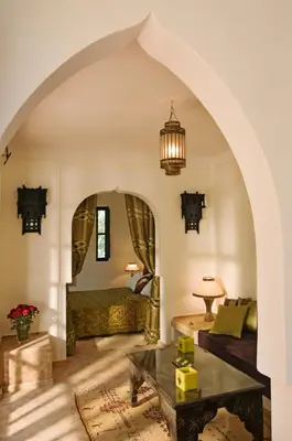 an arched living room with a bed and a table at Villa Dinari in Douar Caïd Layadi