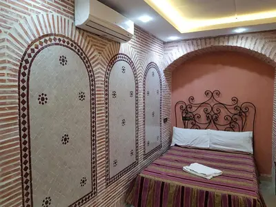 a bedroom with a bed with an ornate wall at Hotel Salsabil in Marrakech