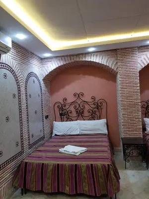 a bedroom with a bed in a brick wall at Hotel Salsabil in Marrakech