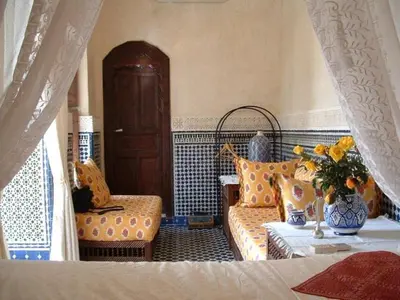 a room with a bed and a couch and a chair at Nadir Home in Marrakech