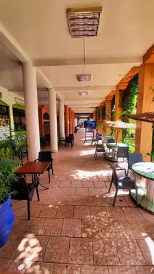 a patio with tables and chairs in a building at Riad Prestigia in Marrakech