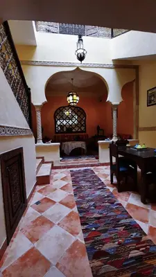 a living room with a table and a rug at Riad Prestigia in Marrakech