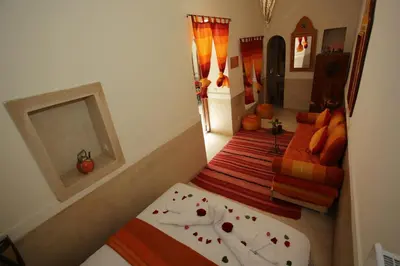 a small bedroom with two beds and a mirror at Riad white flowers in Marrakech