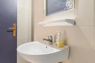 a white bathroom with a sink and a mirror at Villa Lila in Marrakech