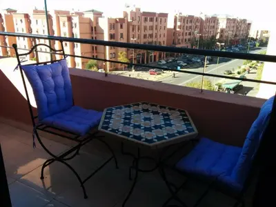 two chairs and a table on a balcony at Superbe appartement avec terrasse in Marrakech