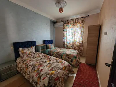 a bedroom with two beds and a window at Superbe appartement avec terrasse in Marrakech