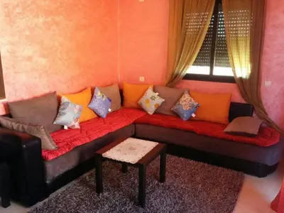 a couch with pillows on it in a living room at Superbe appartement avec terrasse in Marrakech