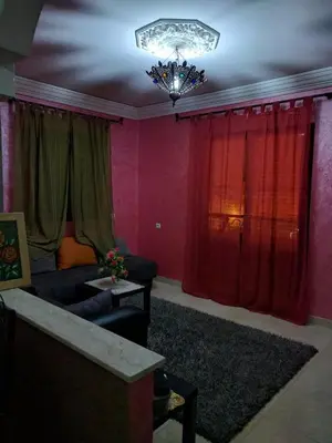 a living room with red curtains and a chandelier at Superbe appartement avec terrasse in Marrakech