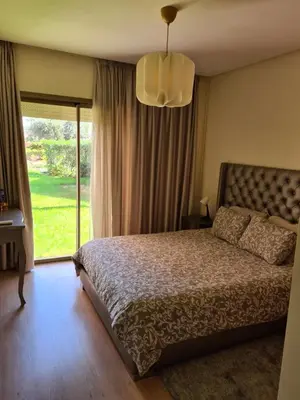 a bedroom with a bed and a large window at Appartement chic avec jardin a Prestigia Golf City in Marrakech