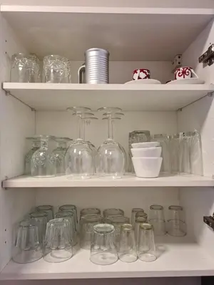 a shelf filled with glass jars and bowls at Appartement chic avec jardin a Prestigia Golf City in Marrakech