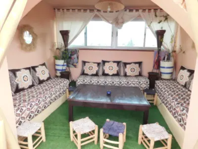 a room with two couches and a table and chairs at New Bahia in Marrakech