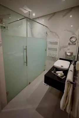 a bathroom with a glass shower and a toilet at Sillage Palace Sky & Spa in Marrakech