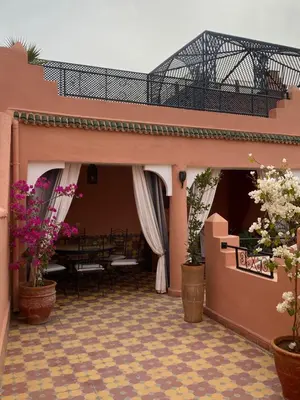 a patio with potted plants and a table in a building at Dar Sarah-Mouassine-Marrakech, Riad authentique idéalement situé in Marrakech