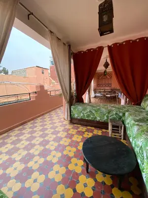 a living room with a green couch and a table at Dar Sarah-Mouassine-Marrakech, Riad authentique idéalement situé in Marrakech