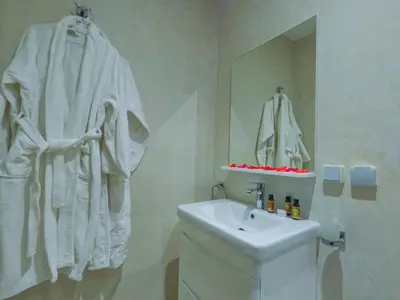 a white bathroom with a sink and a mirror at RIAD REDWAN in Marrakech