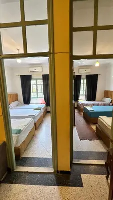 a room with three beds and a window at Dar el Koutoubia in Marrakech