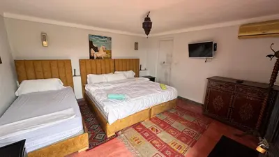 a hotel room with two beds and a tv at Dar el Koutoubia in Marrakech