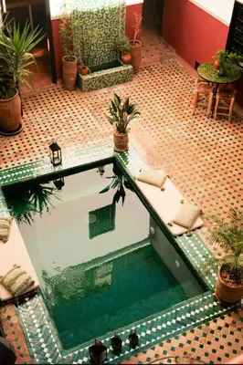a pool in the middle of a room with plants at Riad Nanou - Private Riad with Pool & Rooftop in Marrakech