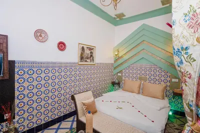 a bedroom with a bed and a blue and white wall at Riad Nouceiba Marrakech in Marrakech